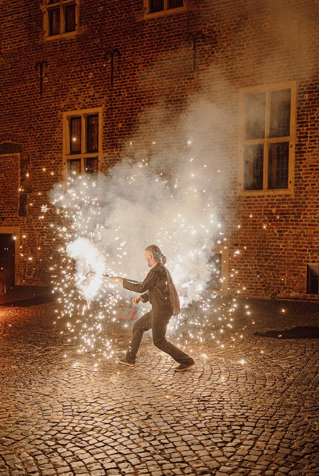 Professionelle Feuerperformance mit Funkenregen vor historischer Kulisse